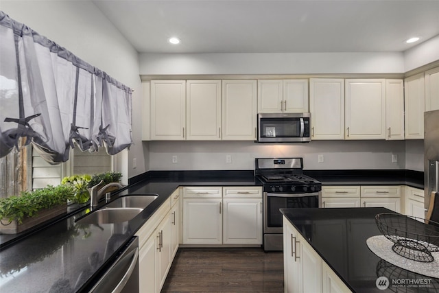 kitchen featuring appliances with stainless steel finishes, dark wood finished floors, recessed lighting, and a sink