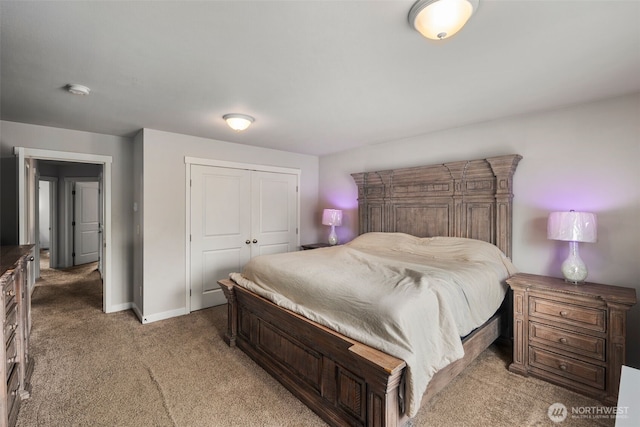 bedroom with light colored carpet, a closet, and baseboards