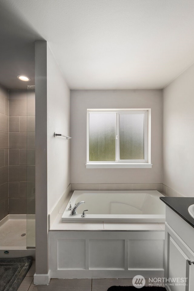 bathroom with a bath, a shower stall, vanity, tile patterned floors, and recessed lighting