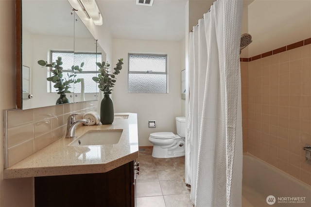 full bath with toilet, healthy amount of natural light, vanity, and tile patterned floors