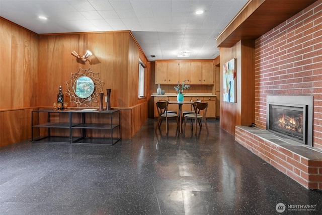 reception area featuring a brick fireplace and wood walls