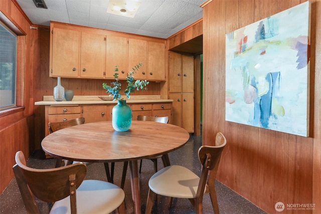 dining room featuring wooden walls