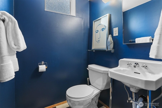 bathroom with toilet and baseboards