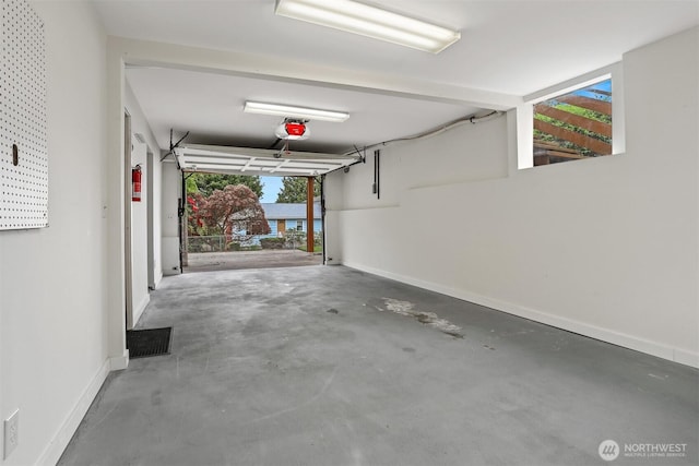 garage featuring a garage door opener and baseboards