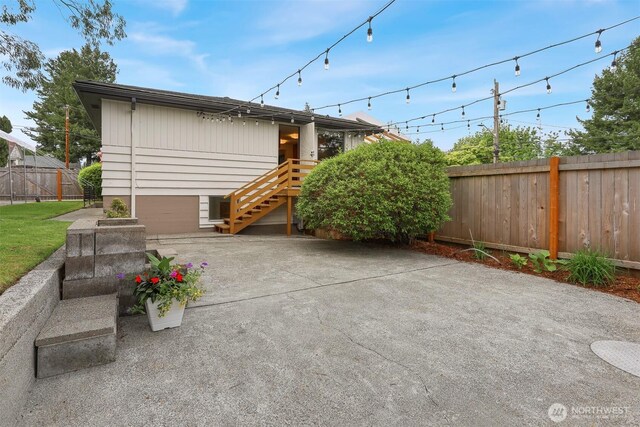 rear view of house featuring a fenced backyard, a patio, and stairs