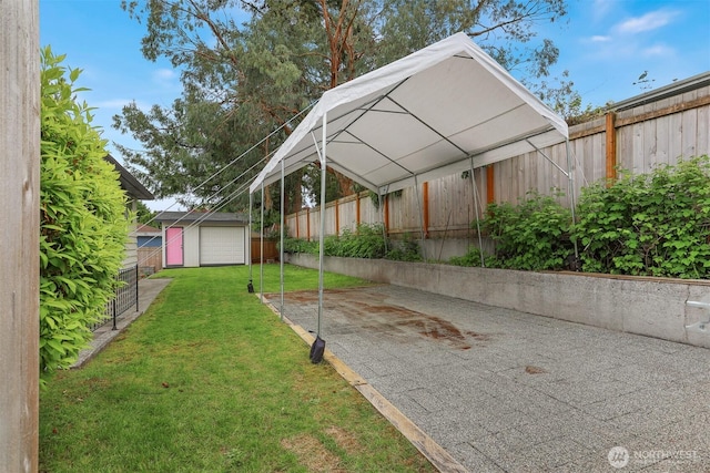 view of yard with an outbuilding, a carport, and driveway