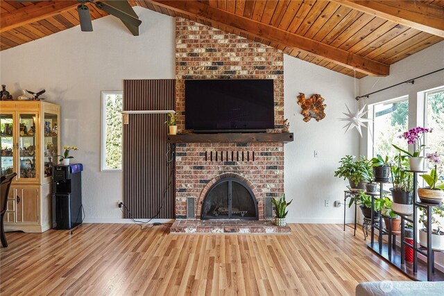 living area with wood finished floors, wooden ceiling, healthy amount of natural light, and a brick fireplace