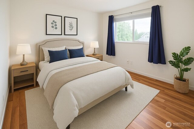 bedroom with baseboards and wood finished floors