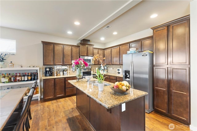 14464 99th Way SE, Yelm, WA 98597 - kitchen featuring stainless steel appliances, a sink, backsplash, light wood finished floors, and light stone countertops