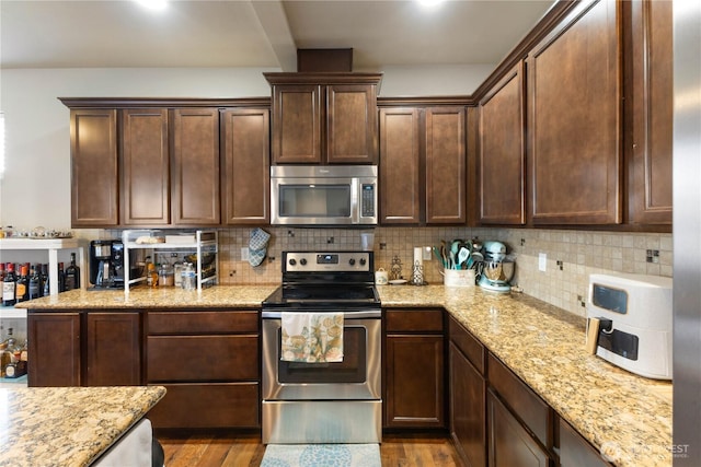 14464 99th Way SE, Yelm, WA 98597 - kitchen featuring appliances with stainless steel finishes, wood finished floors, light stone counters, backsplash, and dark brown cabinets