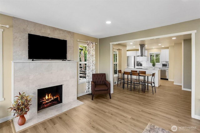 9919 Arrowsmith Ave S, Seattle, WA 98118 - living room featuring light wood-type flooring, a fireplace, baseboards, and recessed lighting