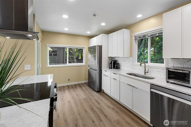 9919 Arrowsmith Ave S, Seattle, WA 98118 - kitchen with appliances with stainless steel finishes, range hood, a sink, light wood-style floors, and backsplash