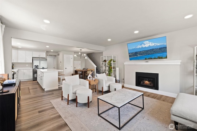3342 Greenwood Ave W, University Place, WA 98466 - living area featuring a glass covered fireplace, recessed lighting, light wood-type flooring, a chandelier, and baseboards