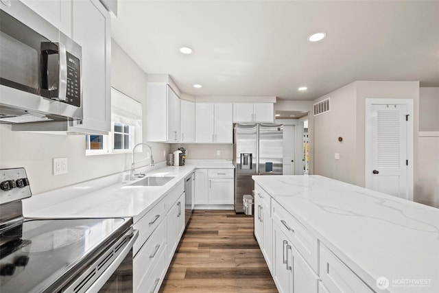 3342 Greenwood Ave W, University Place, WA 98466 - kitchen featuring appliances with stainless steel finishes, a sink, white cabinets, dark wood finished floors, and recessed lighting