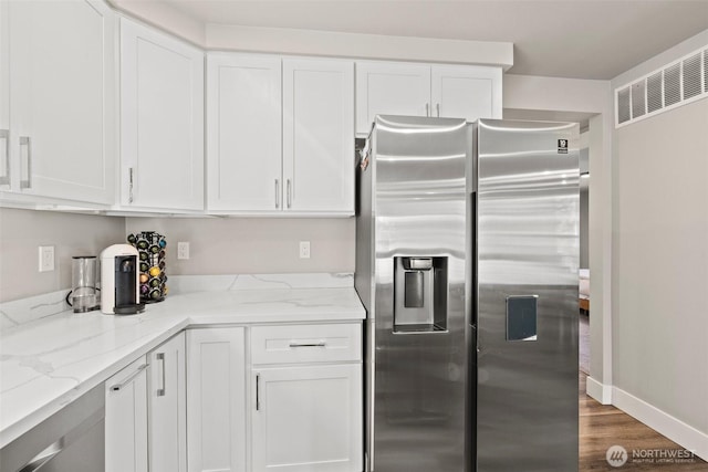 3342 Greenwood Ave W, University Place, WA 98466 - kitchen featuring stainless steel refrigerator with ice dispenser, white cabinets, light stone counters, and dark wood finished floors