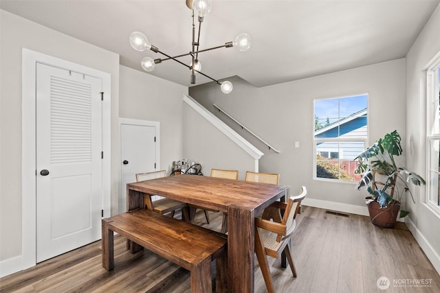 3342 Greenwood Ave W, University Place, WA 98466 - dining room featuring a chandelier, wood finished floors, baseboards, and stairs
