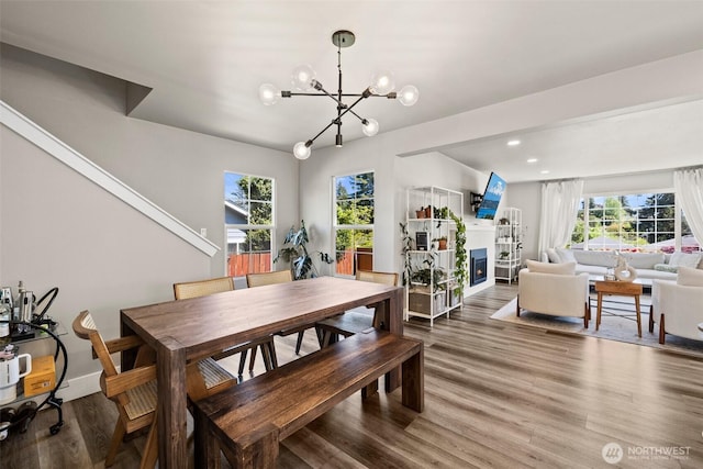 3342 Greenwood Ave W, University Place, WA 98466 - dining area with a glass covered fireplace, wood finished floors, a baseboard radiator, a chandelier, and recessed lighting