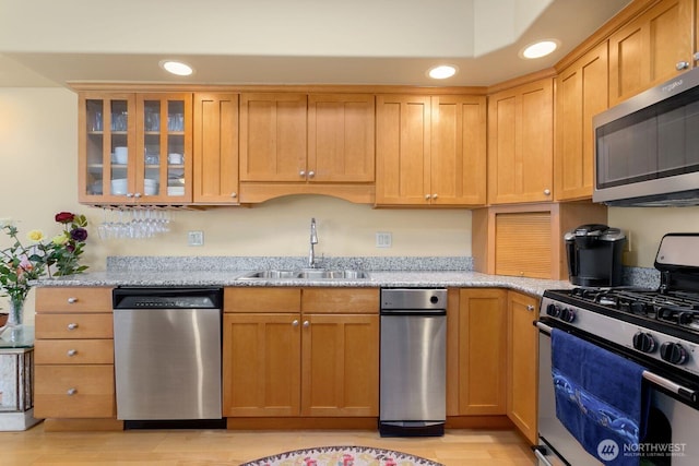 2440 S Steele St Unit 101, Tacoma, WA 98405 - kitchen featuring stainless steel appliances, a sink, recessed lighting, light stone countertops, and glass insert cabinets