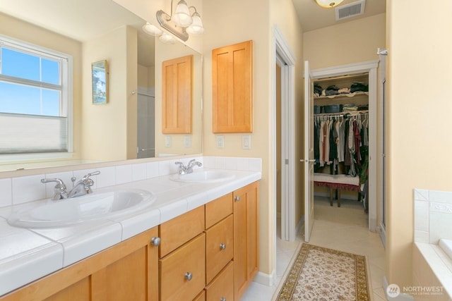 2440 S Steele St Unit 101, Tacoma, WA 98405 - full bath with tile patterned flooring, double vanity, a bathtub, and a walk in closet