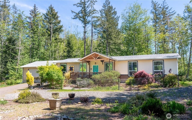 ranch-style home featuring a garage, a fenced front yard, and driveway