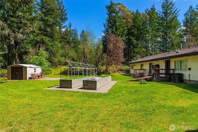 view of grassy yard with a shed, an outbuilding, and a wooden deck