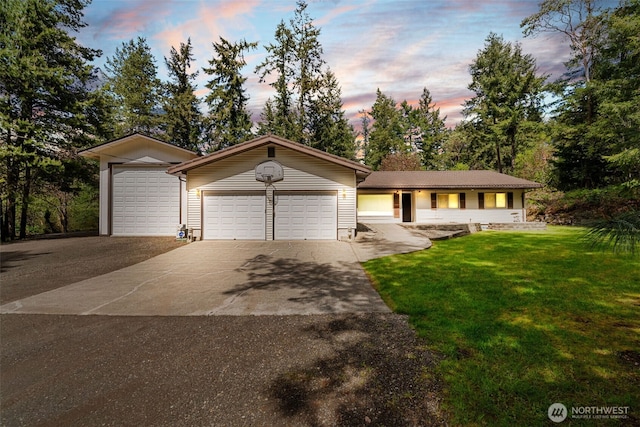 view of front of home featuring concrete driveway, a front yard, and a garage