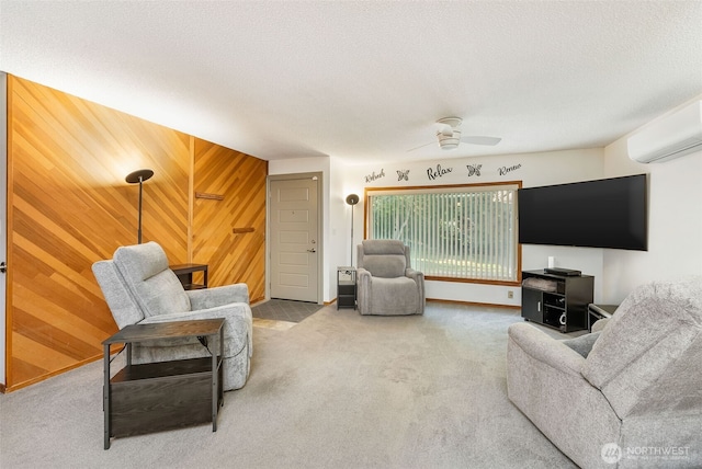living area featuring carpet floors, a ceiling fan, wooden walls, a wall unit AC, and a textured ceiling