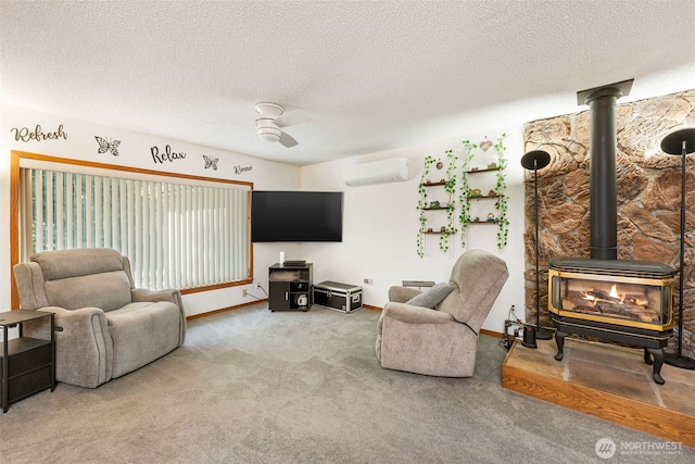 carpeted living room featuring a wood stove, a wall mounted AC, ceiling fan, a textured ceiling, and baseboards