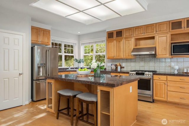 26108 SE 27th St, Sammamish, WA 98075 - kitchen featuring appliances with stainless steel finishes, exhaust hood, a center island, light wood-style floors, and glass insert cabinets