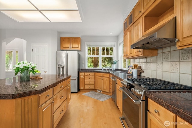 26108 SE 27th St, Sammamish, WA 98075 - kitchen with stainless steel appliances, tile counters, wall chimney exhaust hood, light wood finished floors, and arched walkways
