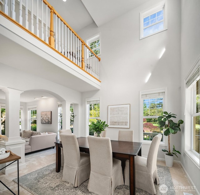 26108 SE 27th St, Sammamish, WA 98075 - dining space with ornate columns, a towering ceiling, plenty of natural light, arched walkways, and baseboards