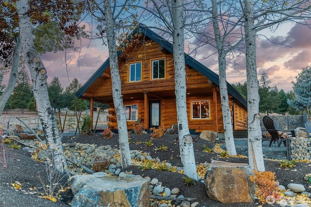 back of property at dusk with a porch