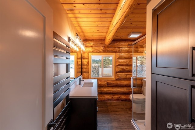bathroom with rustic walls, toilet, wooden ceiling, wood finished floors, and vanity