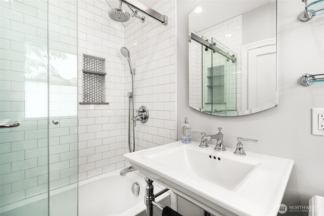 full bath featuring tiled shower / bath and a sink