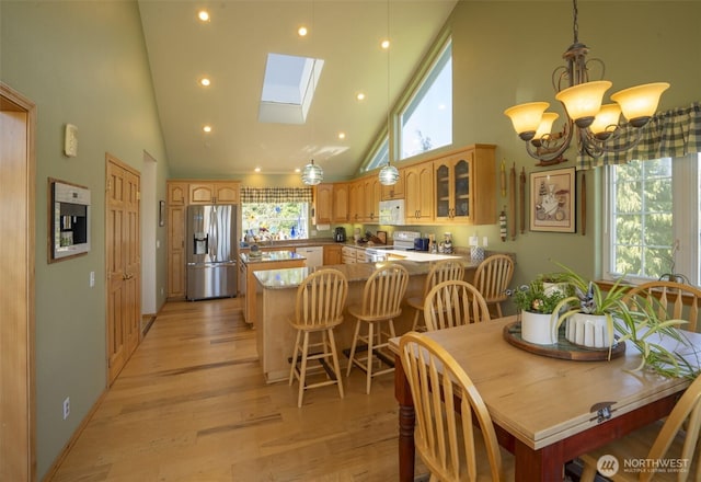 162 W Nelson Rd, Sequim, WA 98382 - dining area with high vaulted ceiling, light wood finished floors, a chandelier, a skylight, and recessed lighting