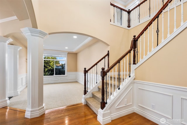 13106 SE 261st Pl, Kent, WA 98030 - stairs with decorative columns, arched walkways, wood finished floors, a decorative wall, and ornamental molding