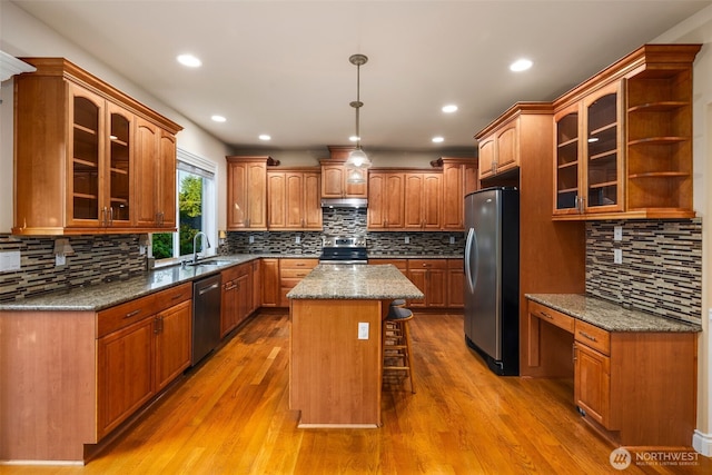13106 SE 261st Pl, Kent, WA 98030 - kitchen with stainless steel appliances, decorative backsplash, a kitchen island, light wood-type flooring, and a kitchen bar