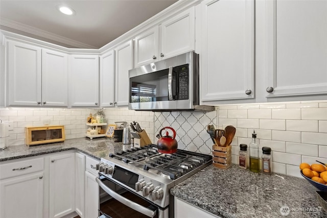 kitchen with appliances with stainless steel finishes, white cabinetry, tasteful backsplash, dark stone counters, and recessed lighting