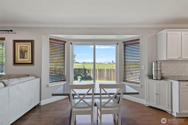 dining room featuring baseboards, dark wood-style floors, and crown molding