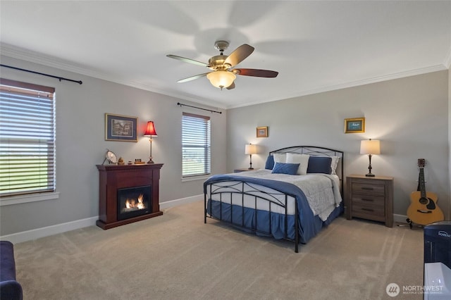 bedroom featuring crown molding, baseboards, light carpet, a glass covered fireplace, and a ceiling fan
