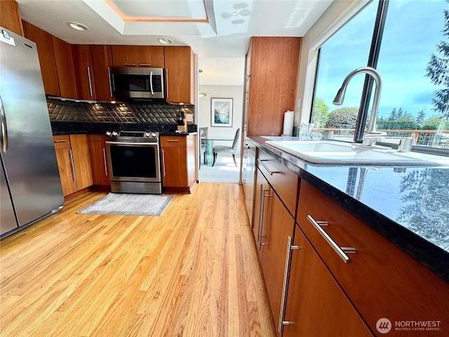 332 162nd Pl SE, Bothell, WA 98012 - kitchen featuring appliances with stainless steel finishes, a sink, brown cabinetry, and light wood finished floors
