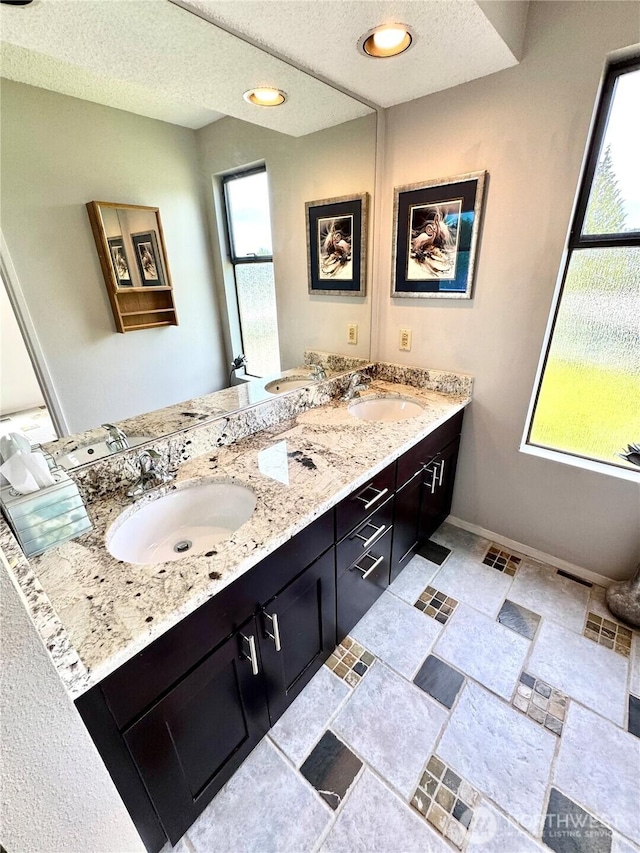 332 162nd Pl SE, Bothell, WA 98012 - bathroom with double vanity, stone finish floors, a textured ceiling, baseboards, and recessed lighting