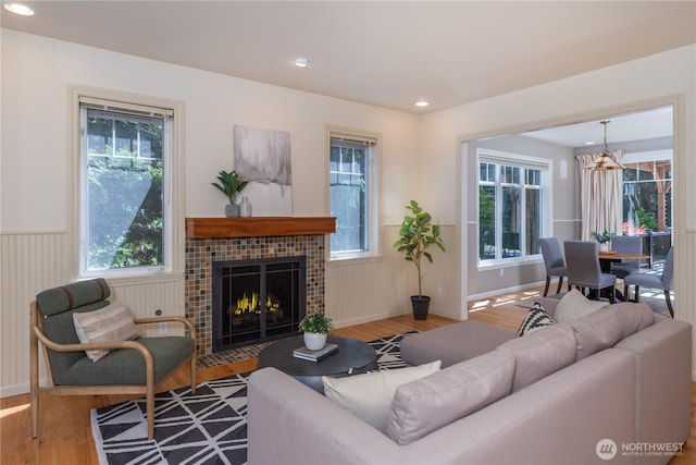 702 Woodland Dr, Port Townsend, WA 98368 - living area with a wainscoted wall, wood finished floors, healthy amount of natural light, a fireplace, and a chandelier
