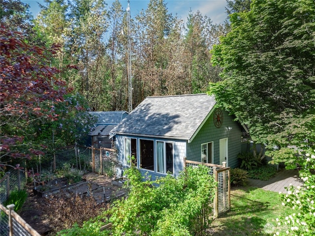 702 Woodland Dr, Port Townsend, WA 98368 - rear view of house featuring a shingled roof, a garden, and fence