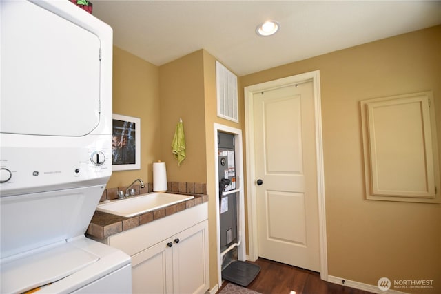 327 Buttercup Ln SW, Mattawa, WA 99349 - washroom with stacked washer / dryer, dark wood-style flooring, and cabinet space