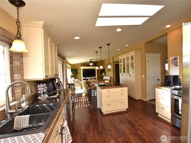 327 Buttercup Ln SW, Mattawa, WA 99349 - kitchen with stainless steel appliances, a sink, dark wood-style flooring, dark countertops, and a skylight