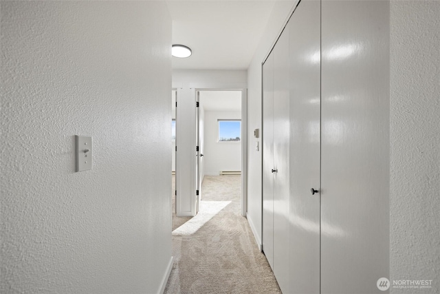 3121 W Hood Ave Unit E203, Kennewick, WA 99336 - hallway with carpet floors, a baseboard radiator, a textured wall, and baseboards