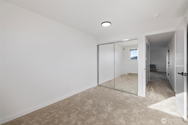 3121 W Hood Ave Unit E203, Kennewick, WA 99336 - unfurnished bedroom featuring carpet flooring, a baseboard radiator, a closet, and baseboards