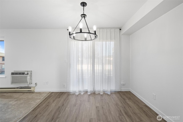 3121 W Hood Ave Unit E203, Kennewick, WA 99336 - unfurnished dining area featuring wood finished floors, a chandelier, baseboard heating, a wall unit AC, and baseboards