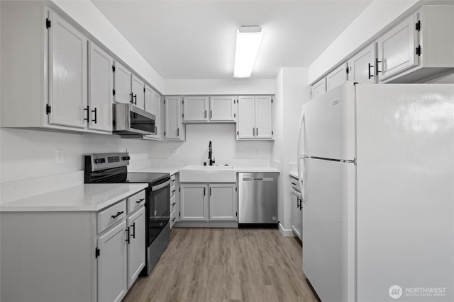 3121 W Hood Ave Unit E203, Kennewick, WA 99336 - kitchen with stainless steel appliances, a sink, light wood finished floors, and light countertops